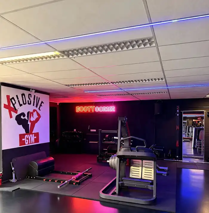 Het logo op de muur naast de trainingsvloer bij Xplosive Gym Helmond