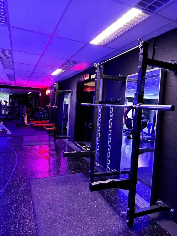 Racks met kettingen in paars en rood licht bij Xplosive Gym Helmond